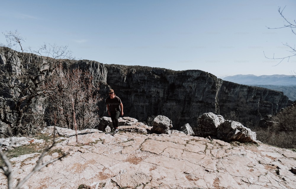 Un uomo in piedi sulla cima di una montagna rocciosa