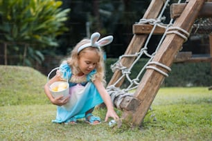 Ein kleines Mädchen in Hasenohren isst eine Schüssel Essen