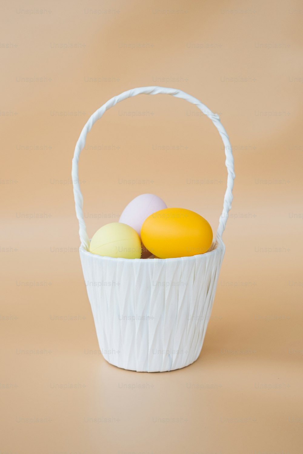uma cesta branca cheia de ovos em cima de uma mesa