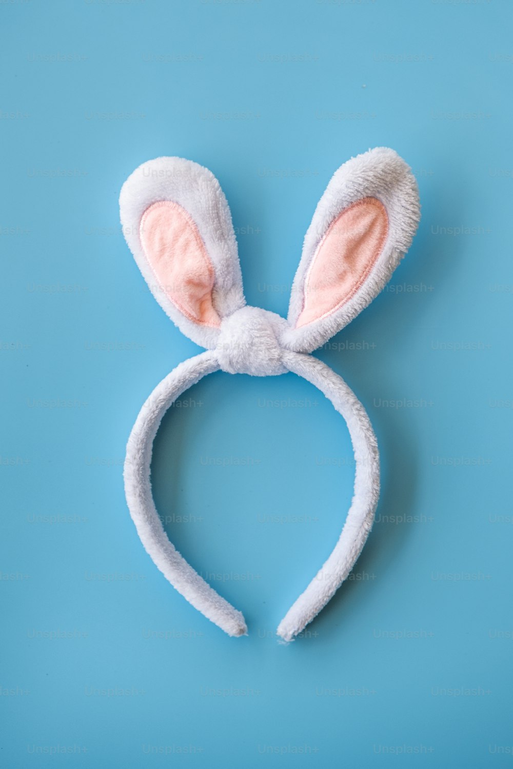 a white bunny ears headband on a blue background