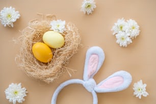 a bunny ears headband next to an egg in a nest
