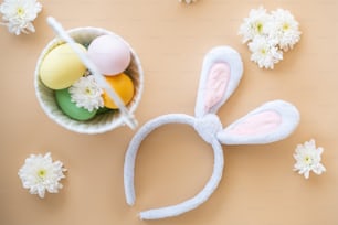 a white bunny ears headband next to a bowl of eggs