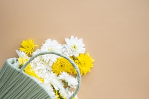 uma cesta cheia de flores brancas e amarelas