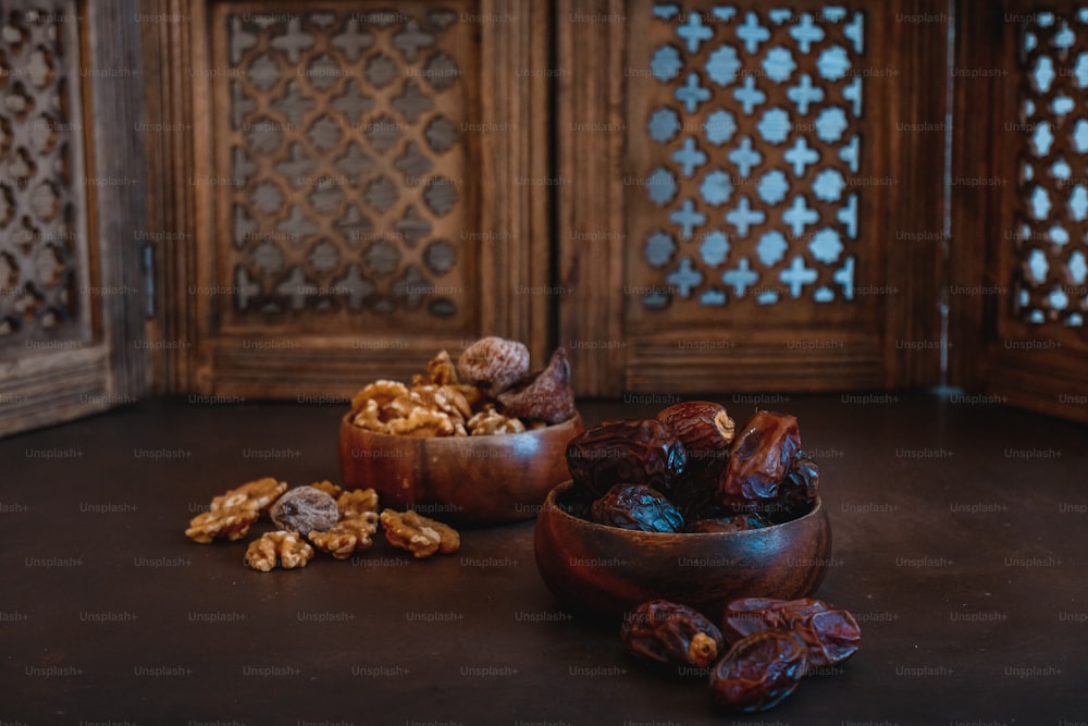 a wooden bowl filled with nuts on top of a table