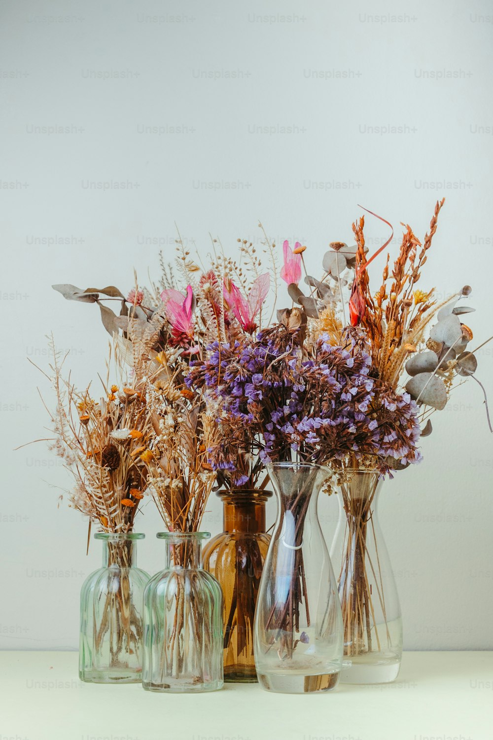 a group of vases filled with different types of flowers