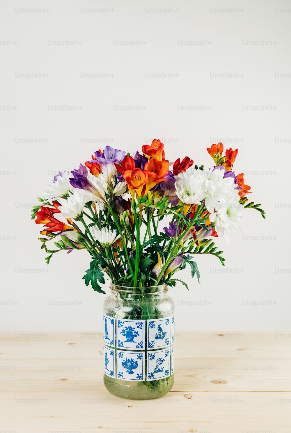 a vase filled with colorful flowers on top of a wooden table