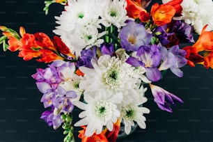 a vase filled with lots of different colored flowers