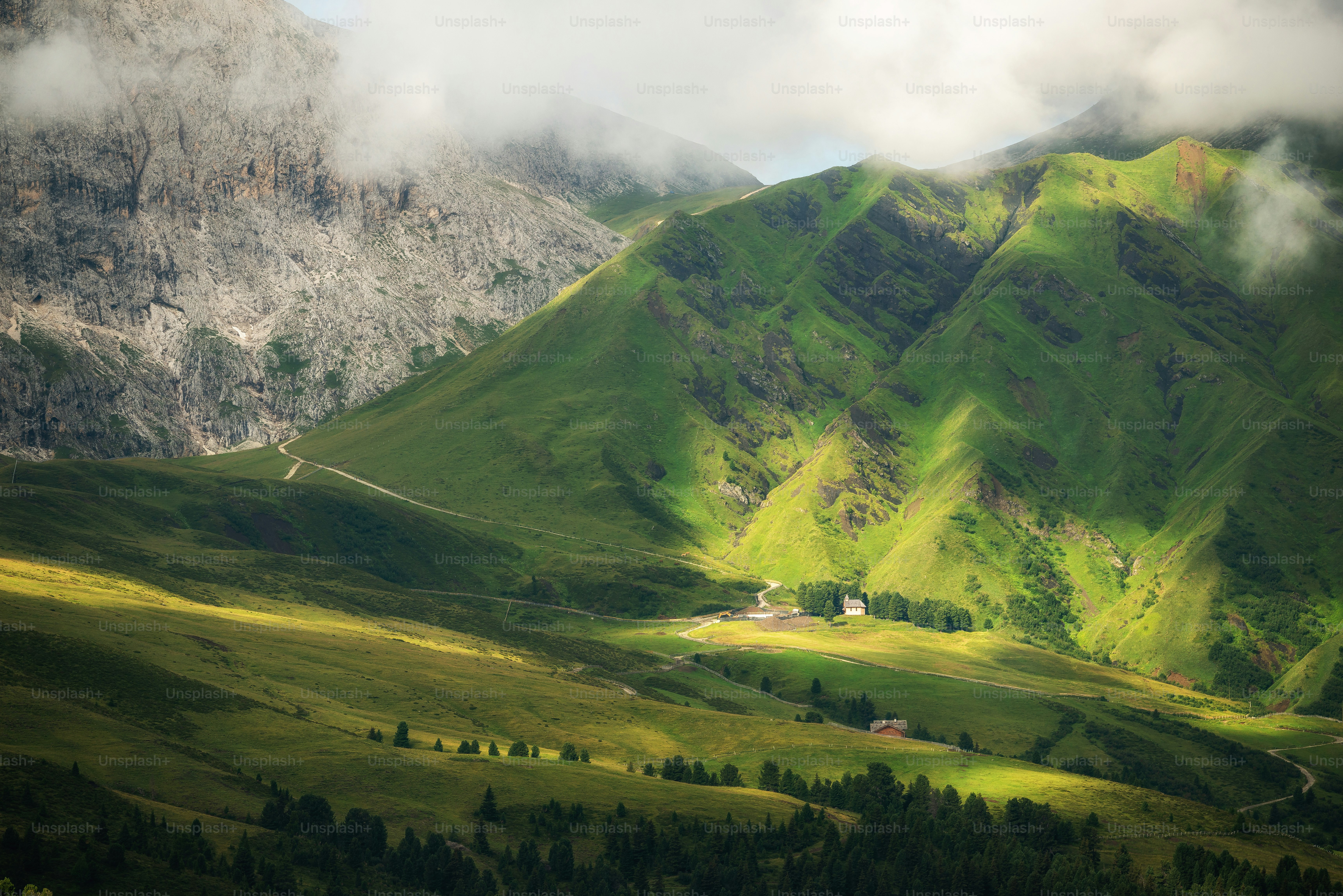Una valle verde lussureggiante circondata da montagne sotto un cielo nuvoloso