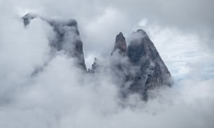 a group of mountains surrounded by clouds in the sky