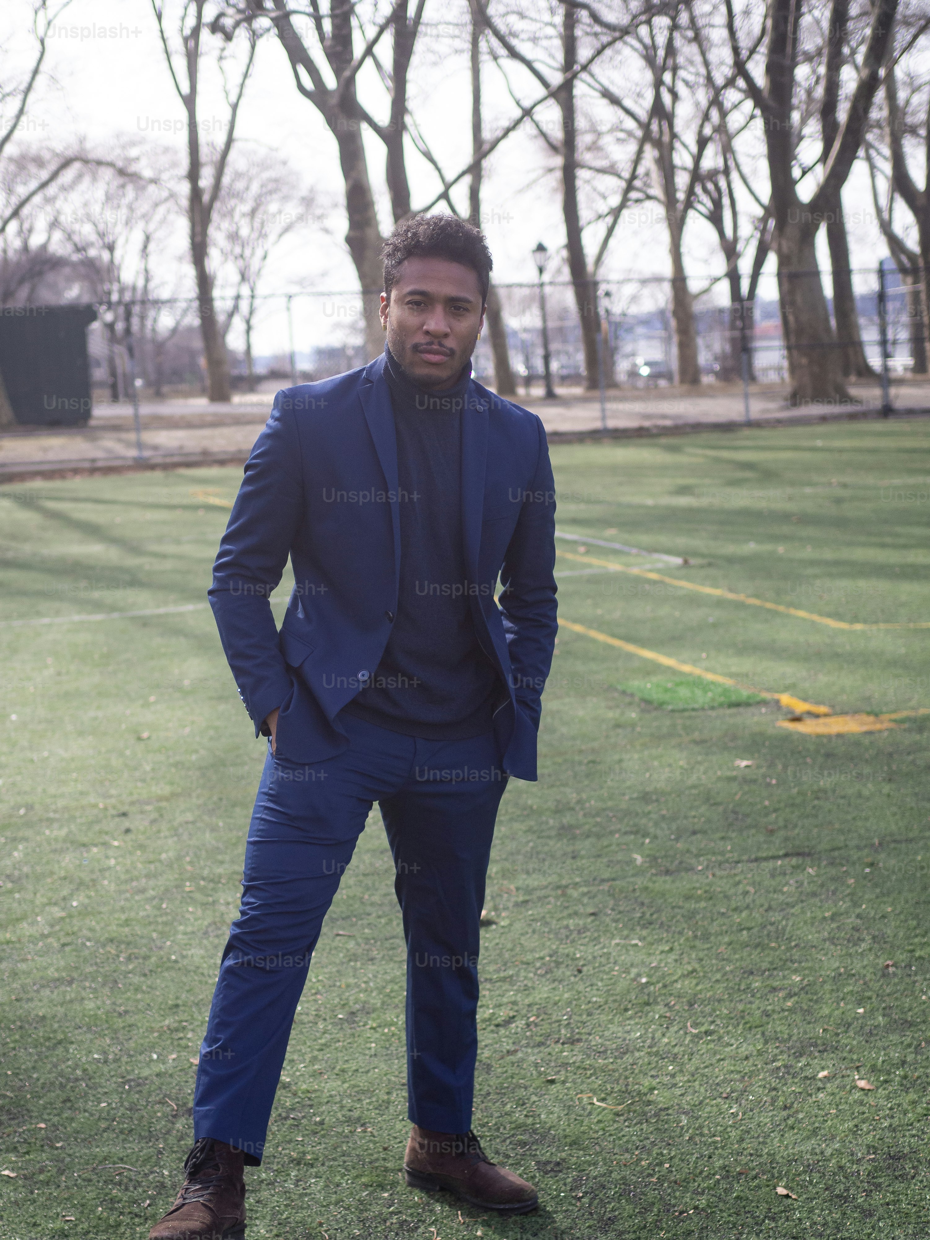 a man in a blue suit standing in the grass
