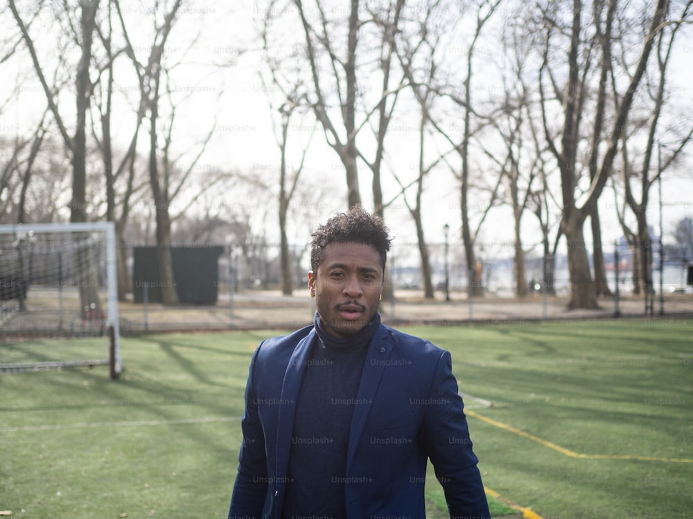 a man in a blue suit standing in front of a soccer goal