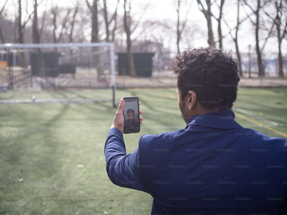 a man taking a picture of a soccer goal