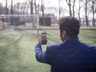 Un hombre tomando una foto de un gol de fútbol