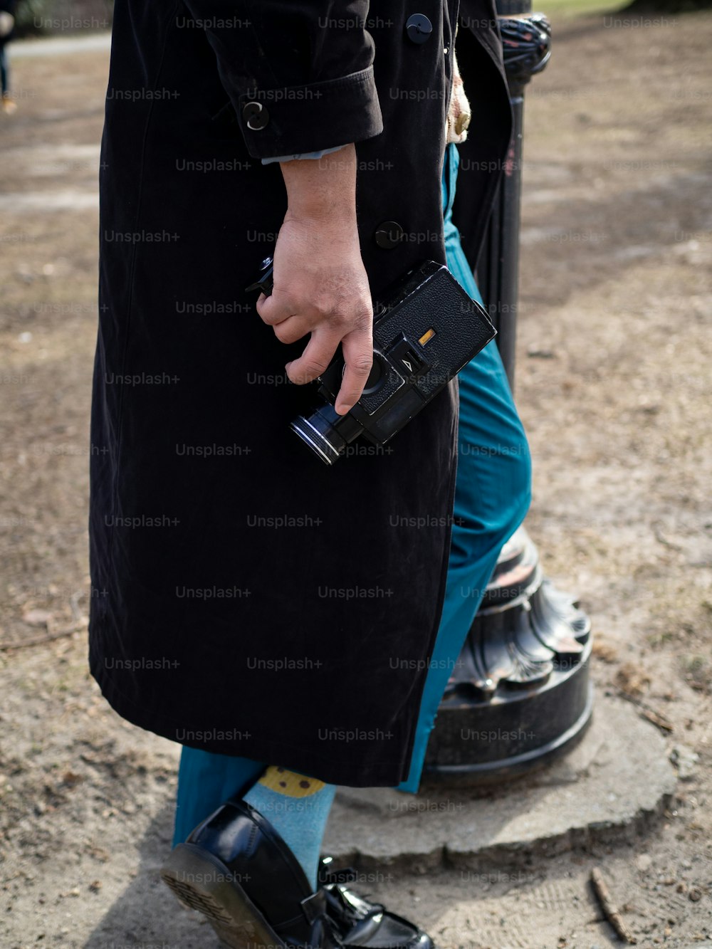 a man in a trench coat holding a camera