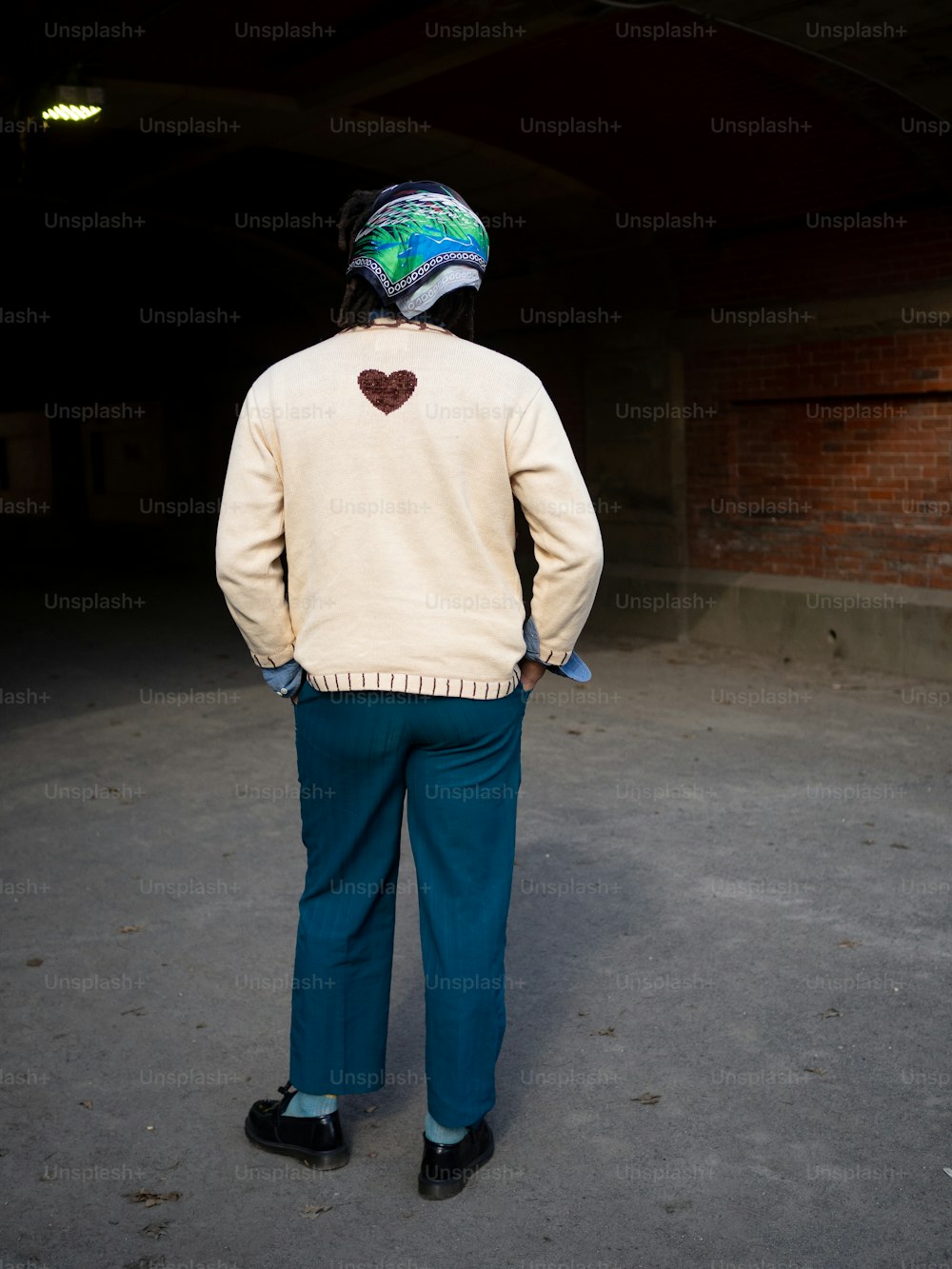 a man standing in a parking garage with his back to the camera