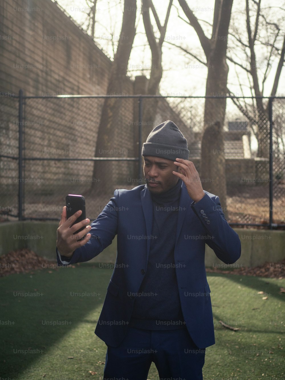 a man in a blue suit is holding a cell phone