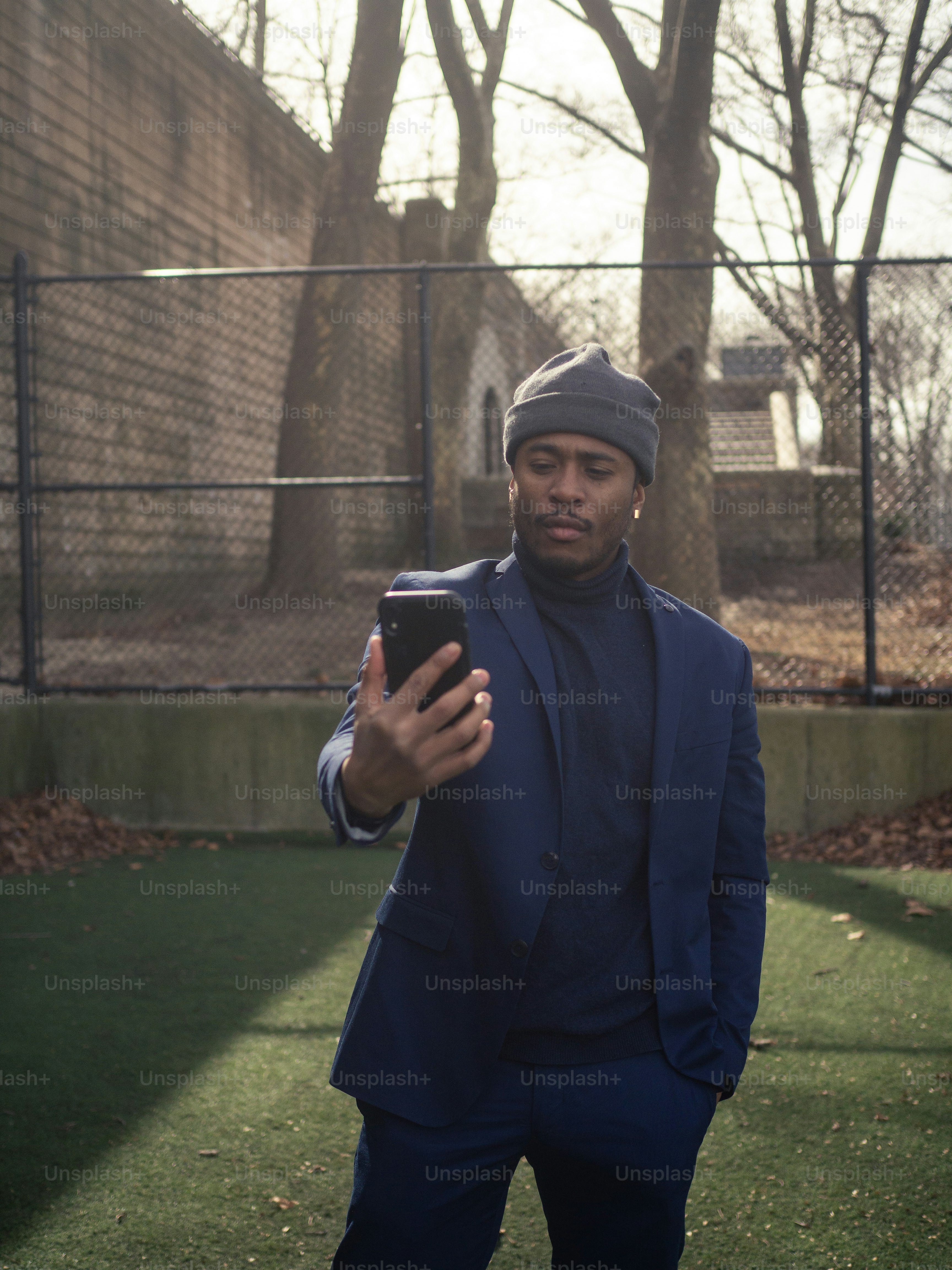 a man in a blue suit is holding a cell phone