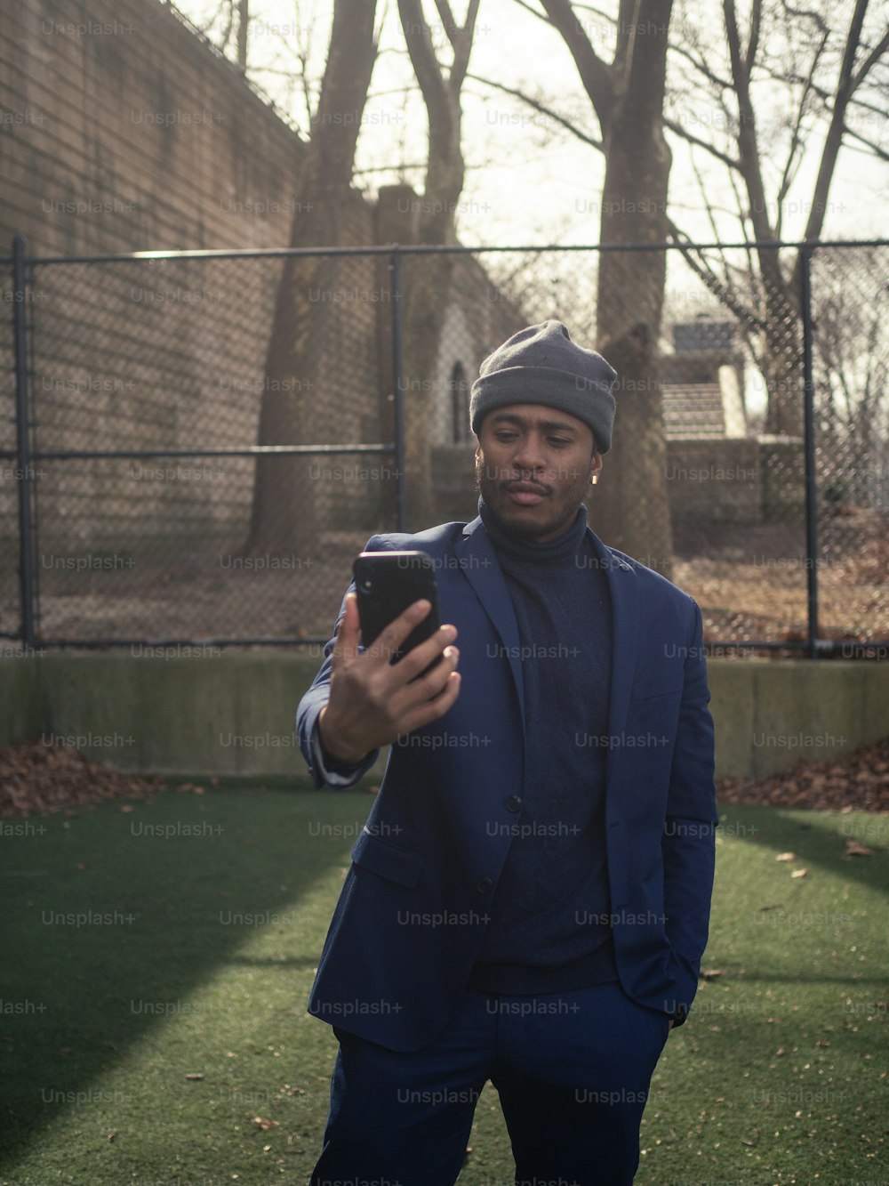 Un homme en costume bleu tient un téléphone portable