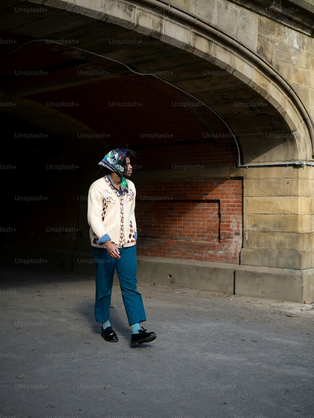 a man standing in a tunnel wearing a hat
