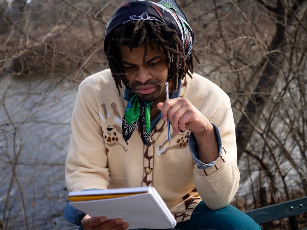 a man with dreadlocks is reading a book