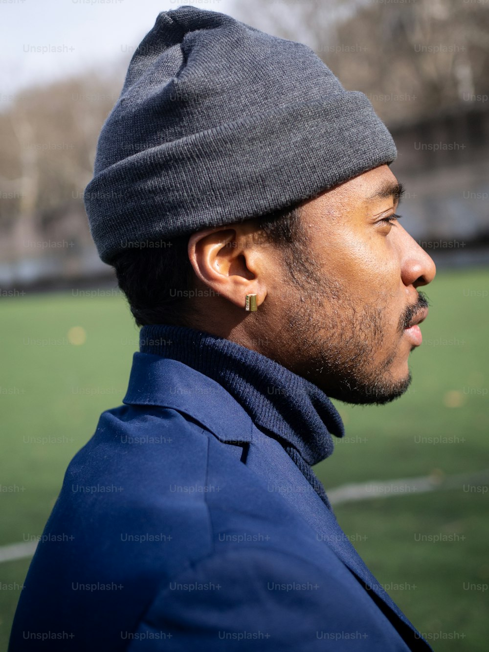 a man wearing a beanie looks off into the distance