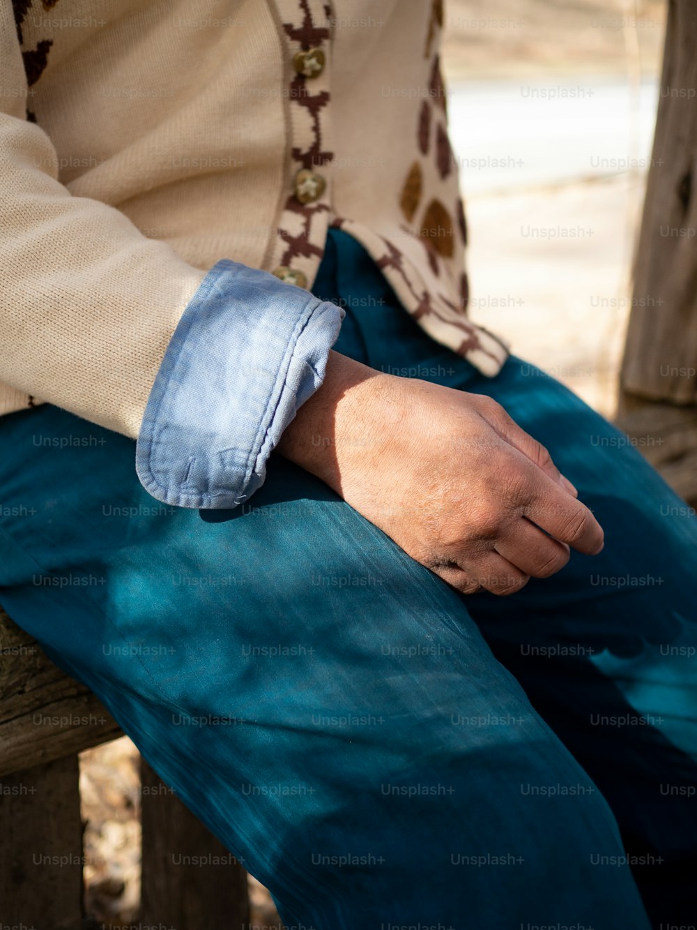 um homem está sentado em um banco com a mão no colo