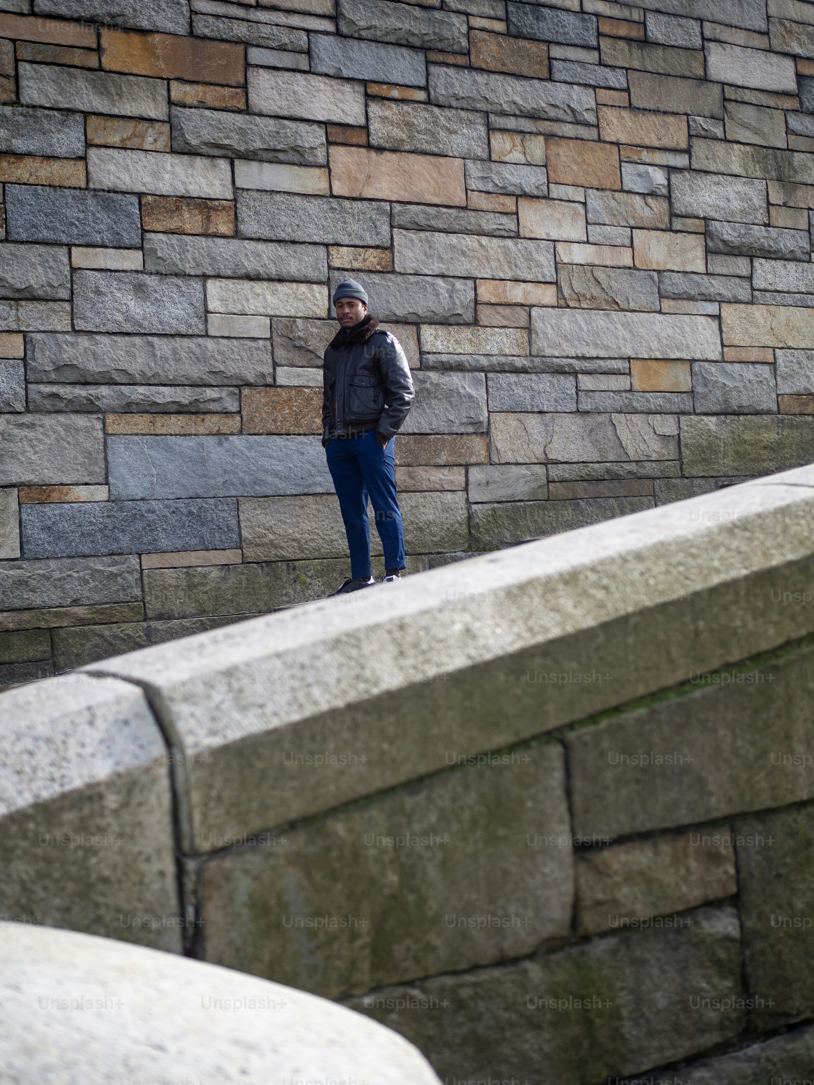 A man standing in front of a stone wall photo – Man Image on Unsplash