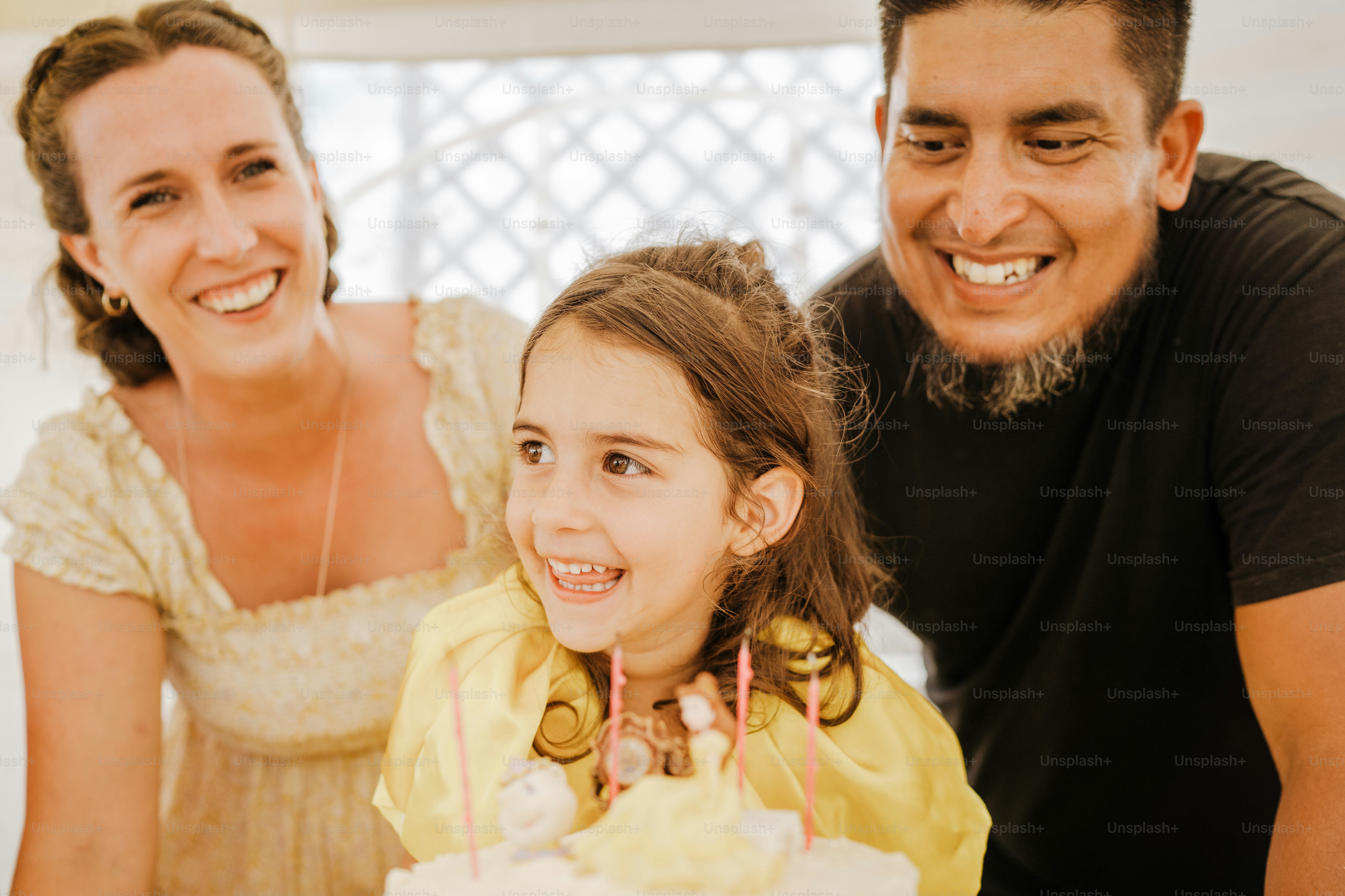 a man and a little girl sitting in front of a cake