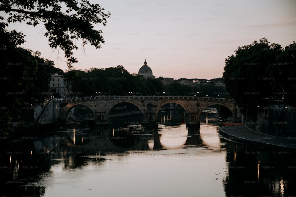 a bridge over a body of water with a building in the background