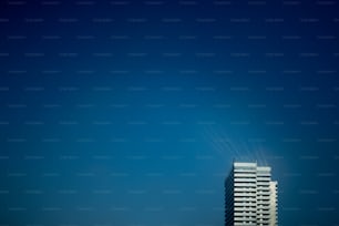 a tall white building with a sky background