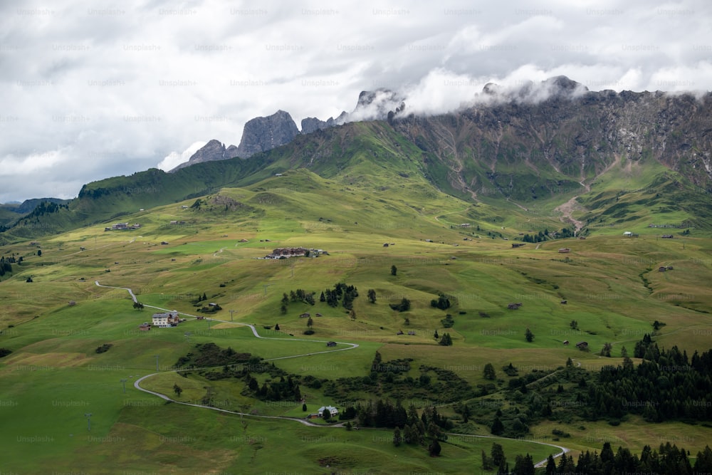 a lush green valley surrounded by mountains under a cloudy sky