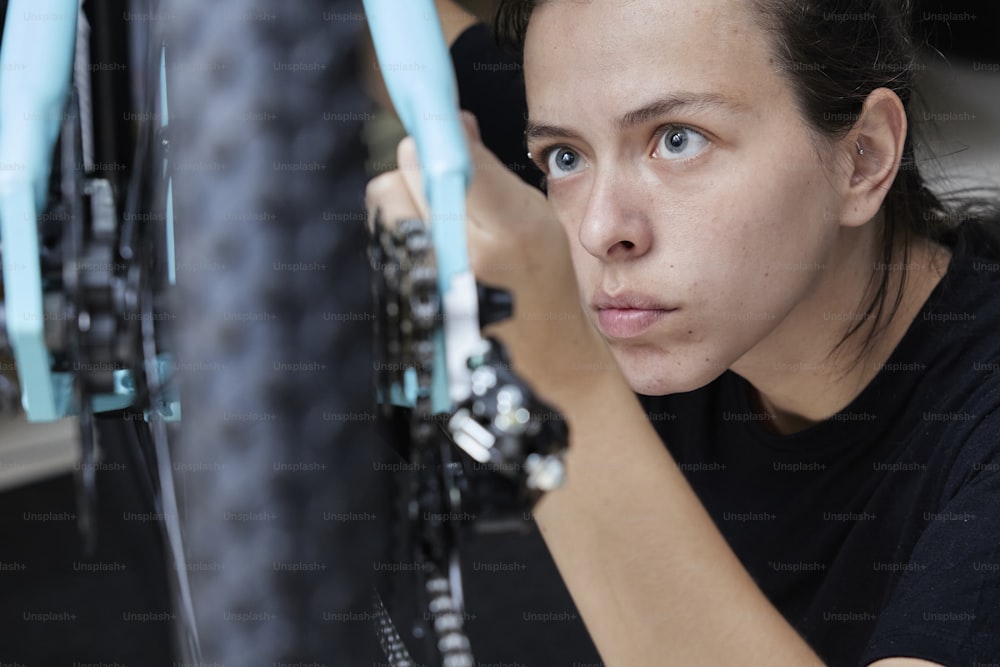 Una donna che lavora su una bicicletta in un negozio di biciclette