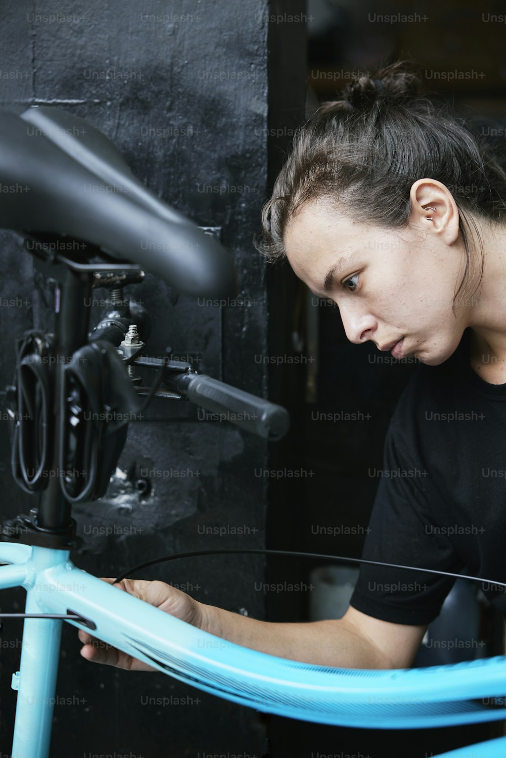 a woman working on a bicycle in a garage