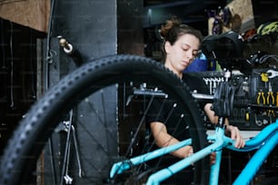 a woman working on a bicycle in a bike shop