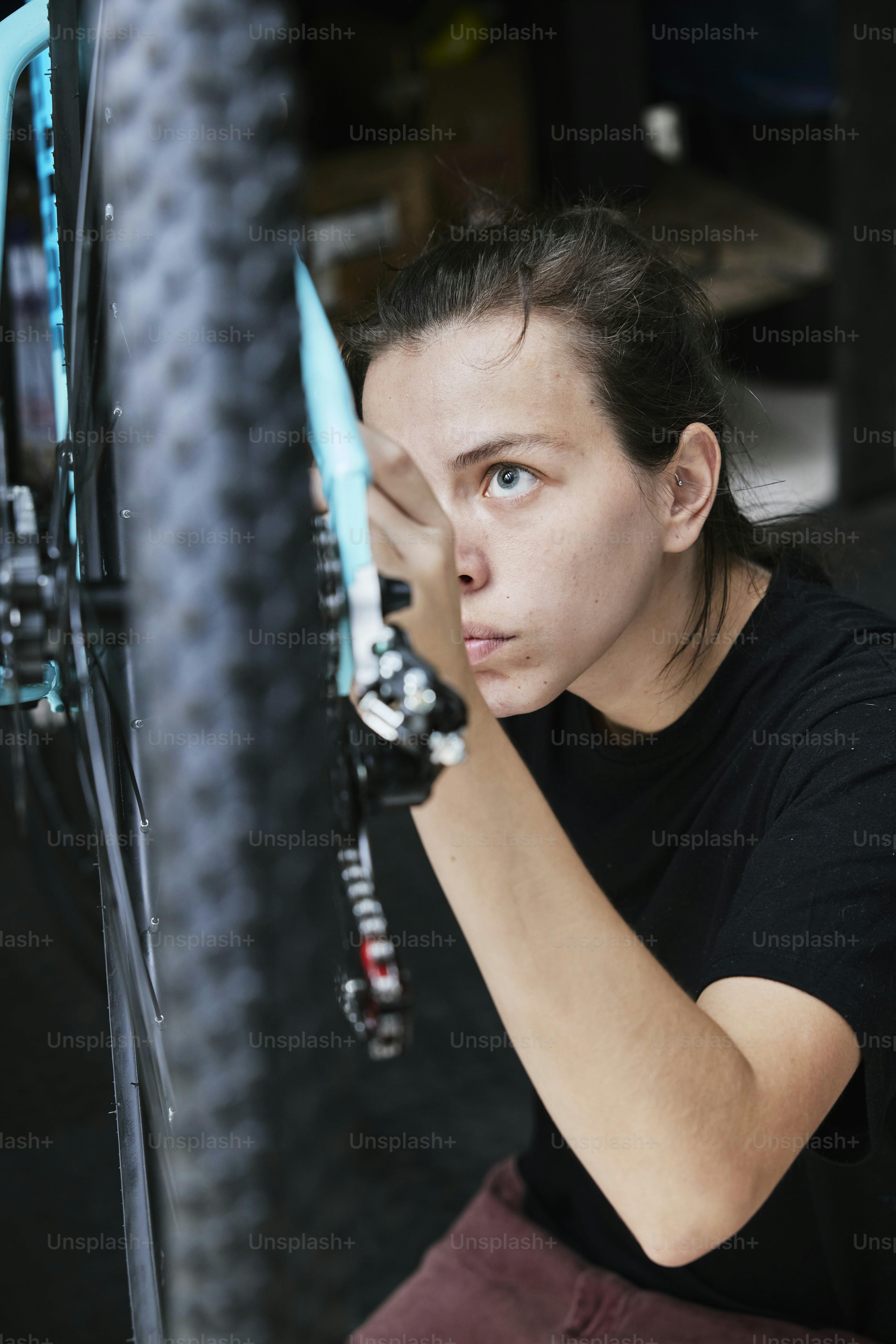 a woman is fixing a bicycle tire with a wrench
