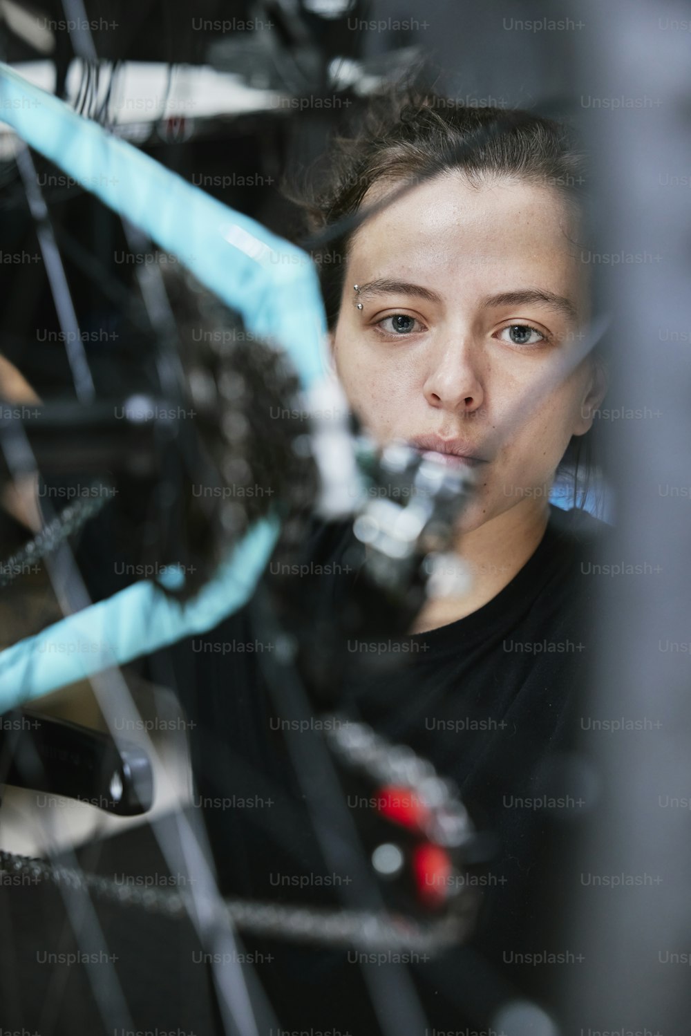 a woman is looking through the spokes of a bicycle