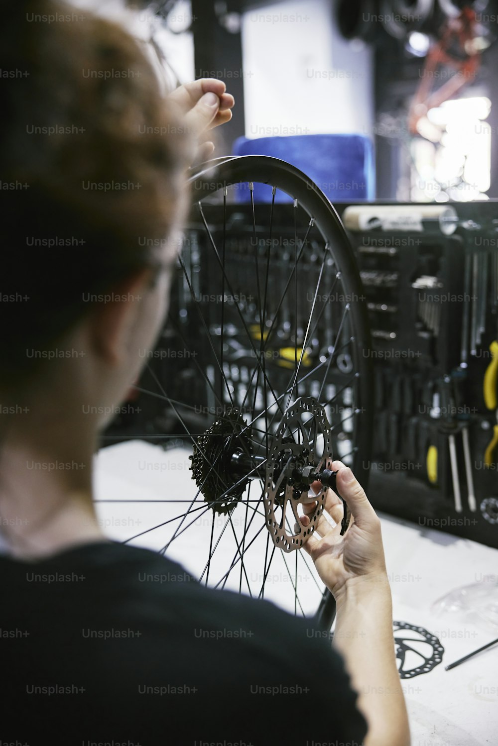 ガレージで自転車の車輪で作業する女性