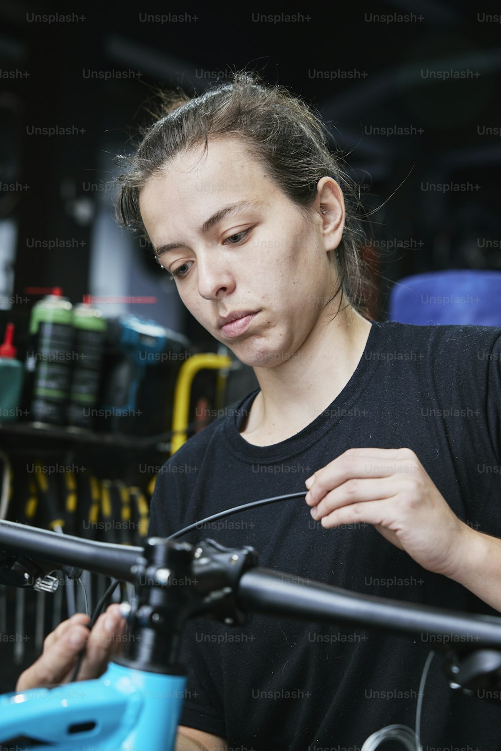a woman working on a bicycle in a shop