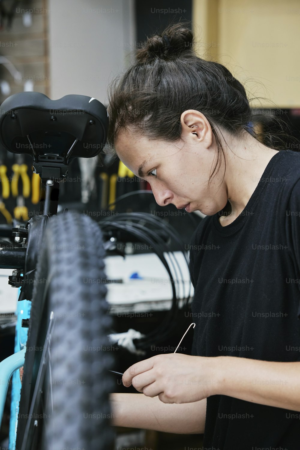 Eine Frau arbeitet an einem Fahrrad in einem Fahrradladen