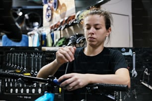 a woman working on a bicycle in a bike shop