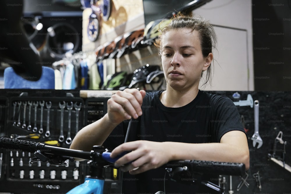 Eine Frau arbeitet an einem Fahrrad in einem Fahrradladen