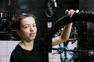 a woman holding a bicycle tire in her hands