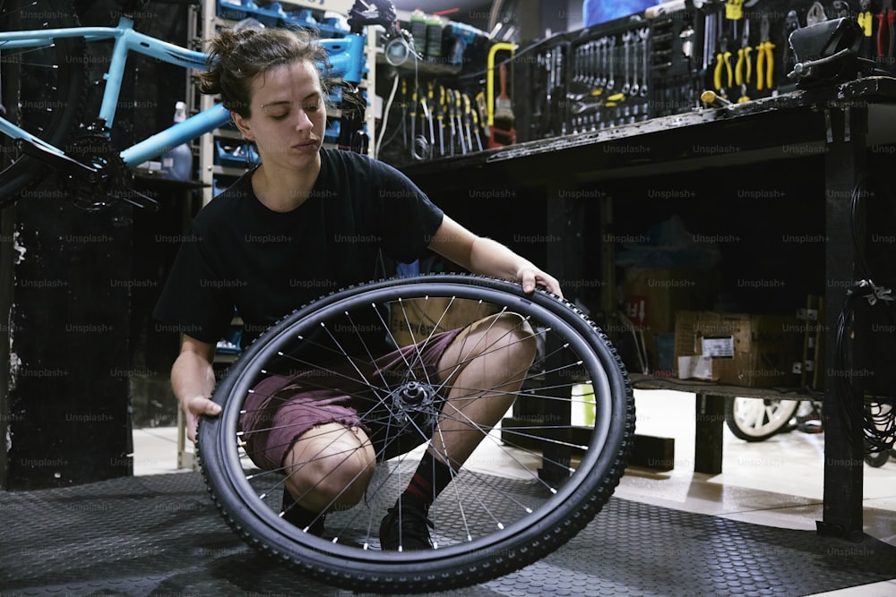 a young man working on a bicycle wheel