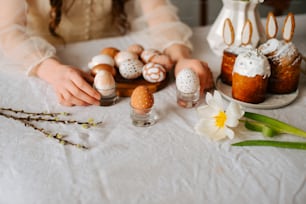 a woman sitting at a table with eggs and flowers