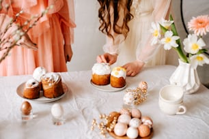 uma mesa coberta com bolos e cupcakes ao lado de um vaso de flores