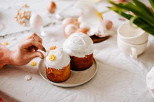 a person is putting icing on some cupcakes