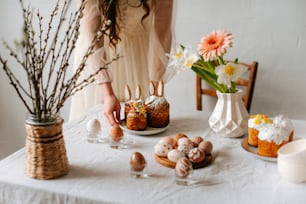 a table topped with cakes and flowers next to a vase of flowers