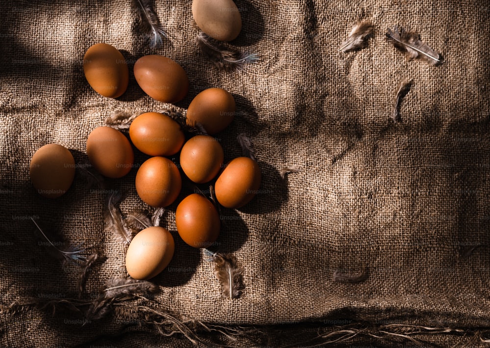 a bunch of brown eggs laying on top of a cloth