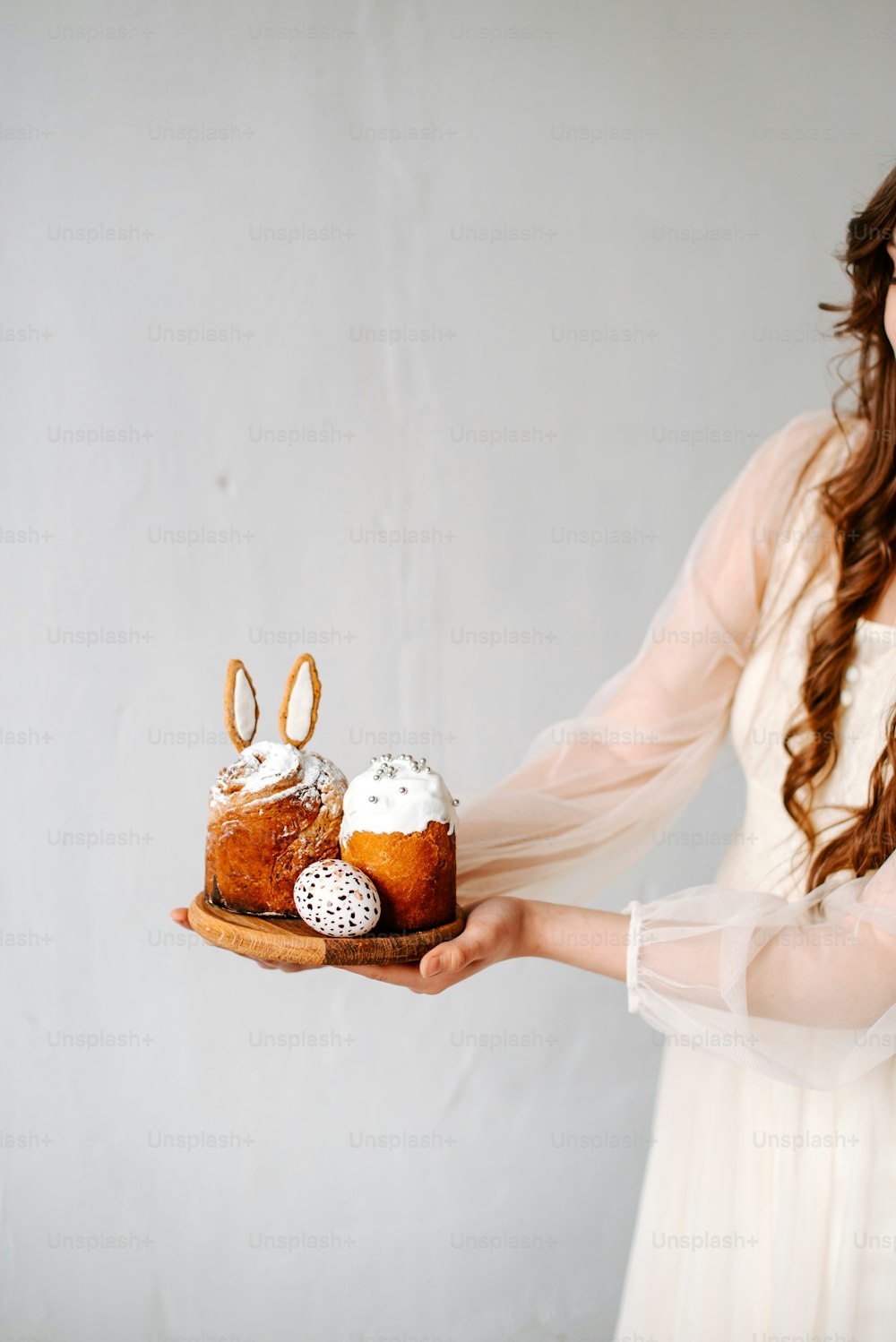 a woman in a white dress holding a cake