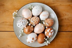 Un plato blanco cubierto con muchos huevos de diferentes colores
